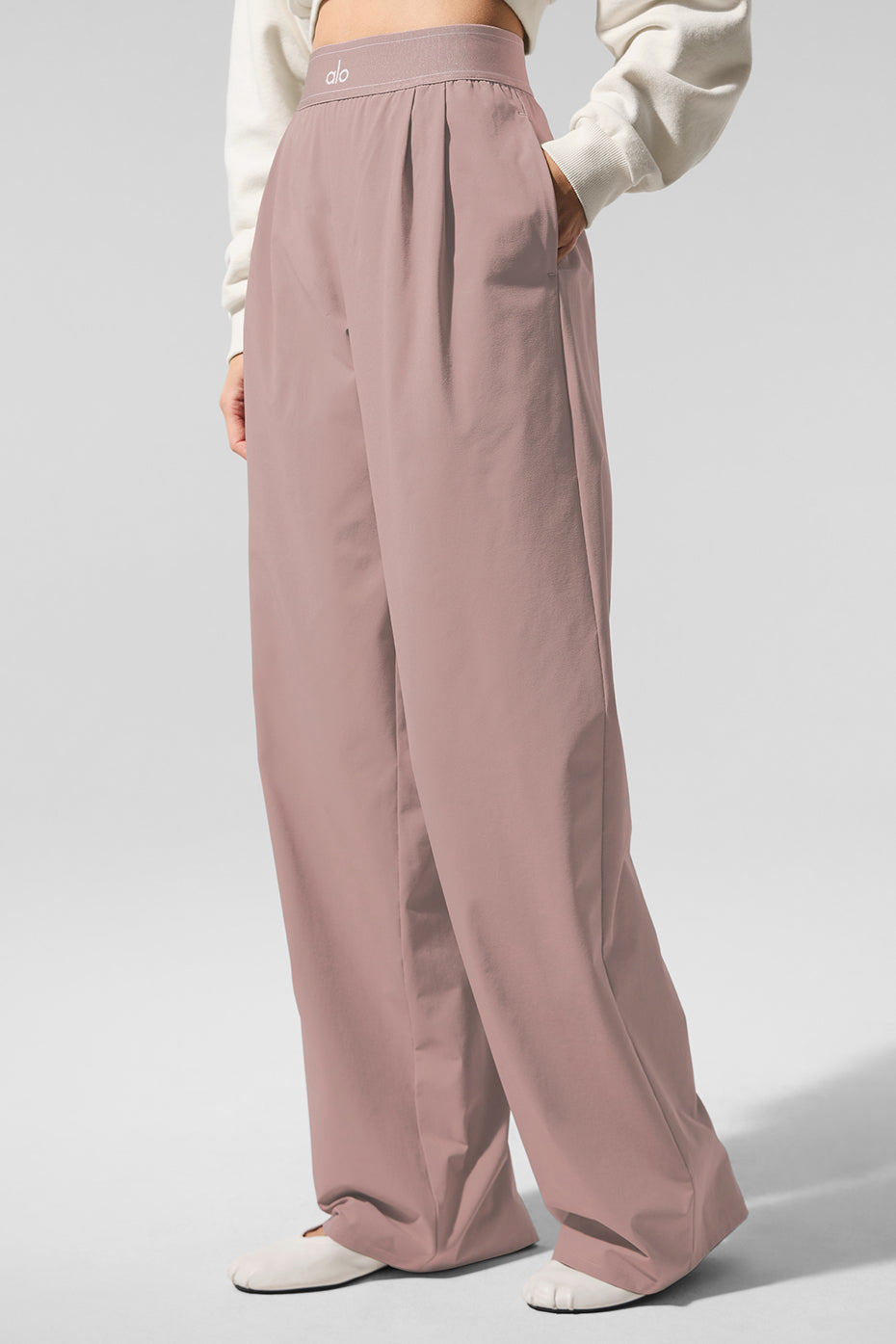 Side view of taupe suit up long trousers with front pleats and elastic waistband
