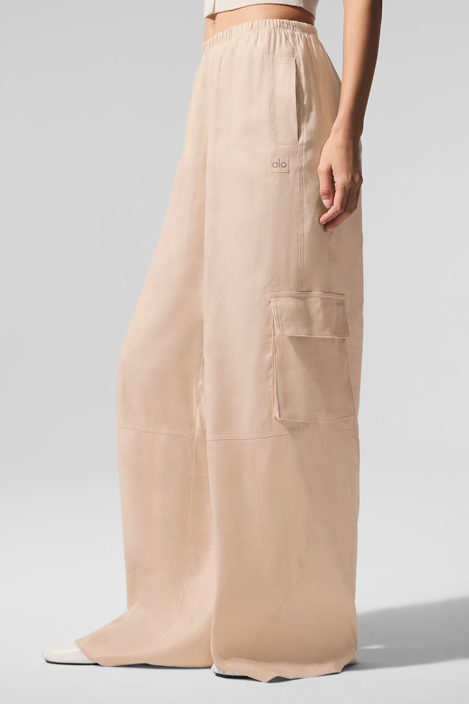 Model wearing linen wide leg pants at a seaside café