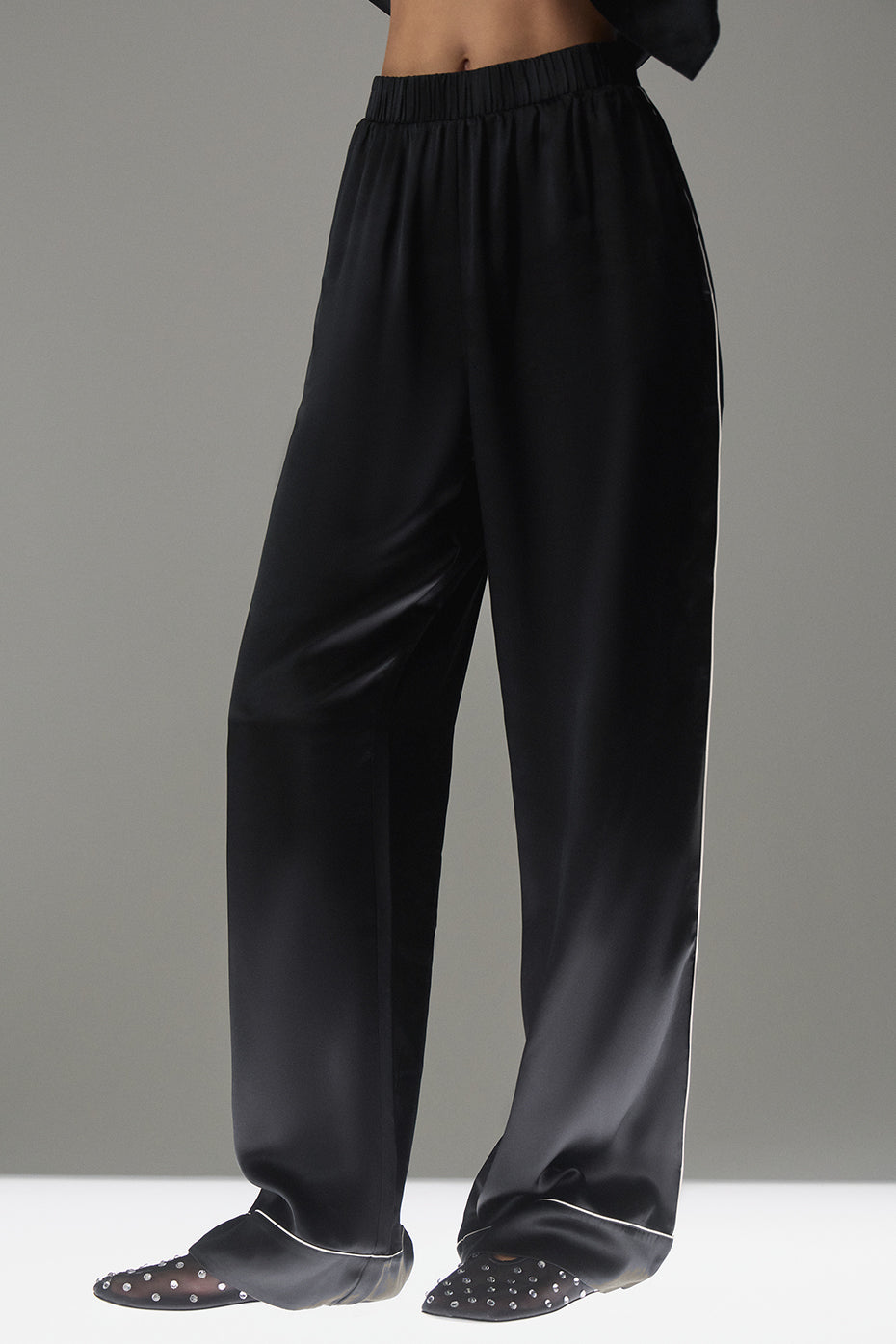 Side view of luxury silk pants highlighting contrast piping.