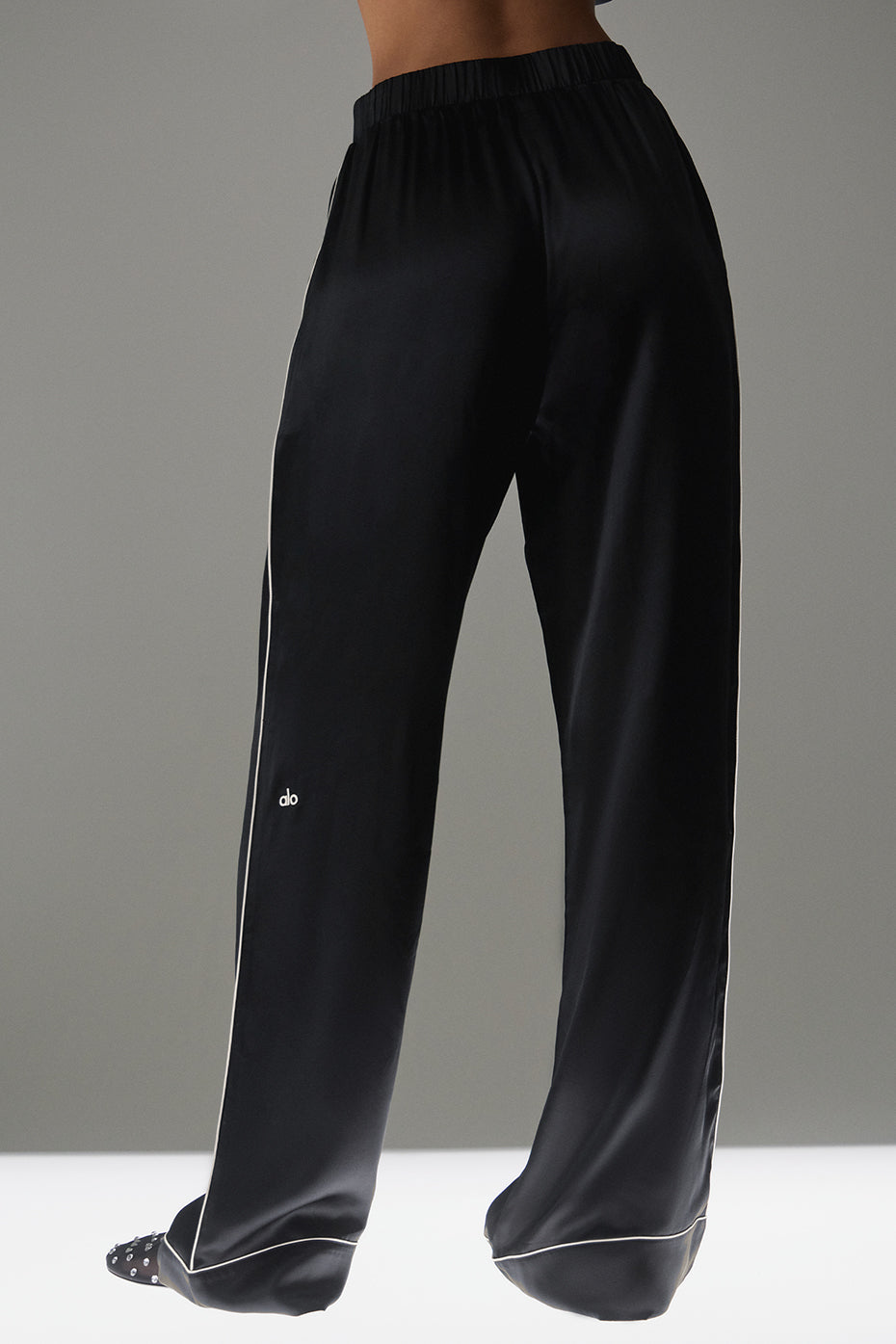 Model wearing white silk pants paired with a chic top.