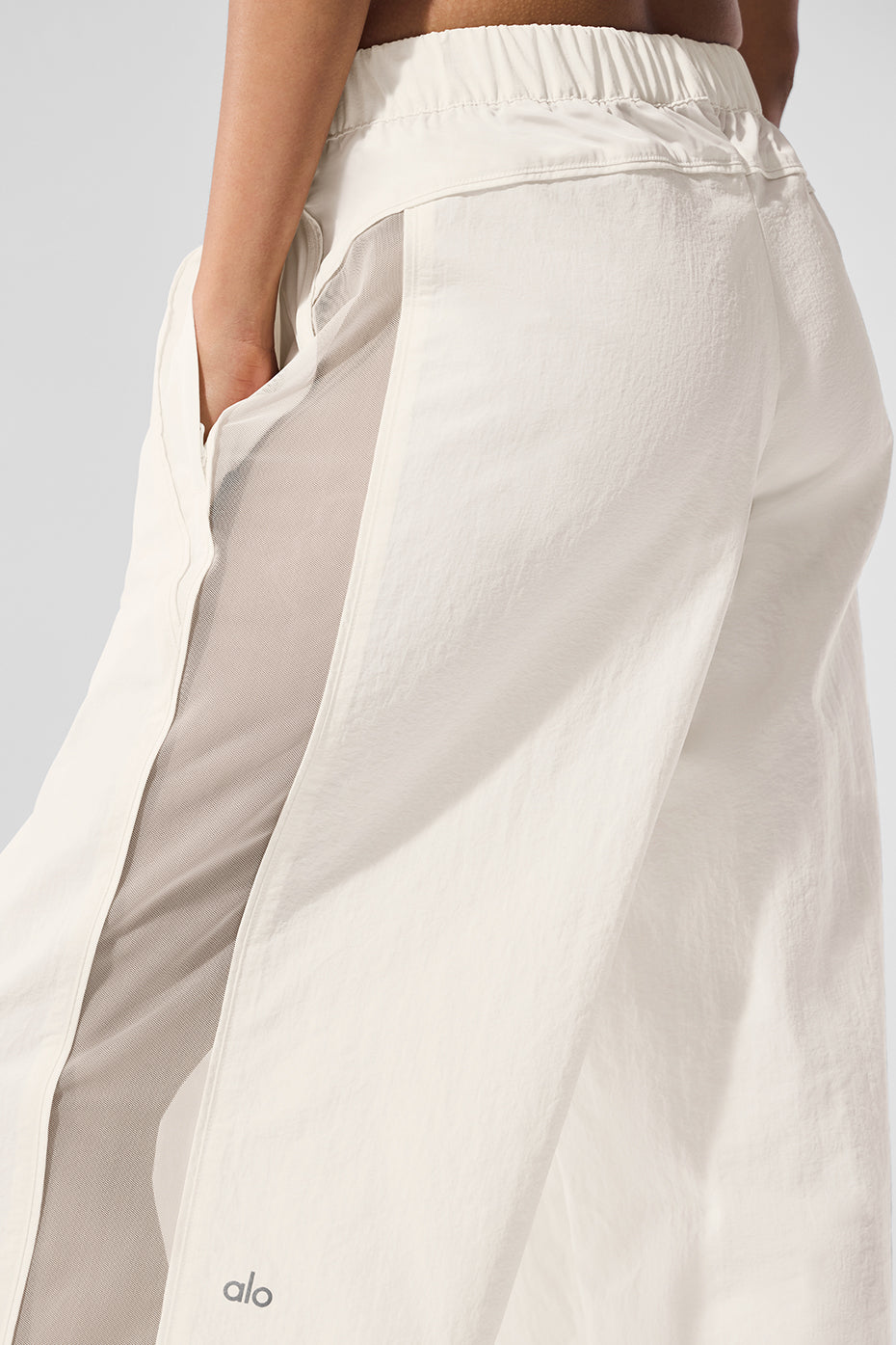 Front view of ivory high-waist wide leg track pants in a casual setting.