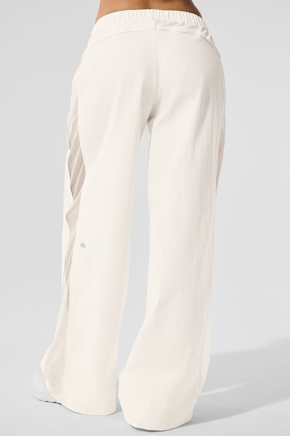 Model wearing ivory high-waist pants track for a trendy look.