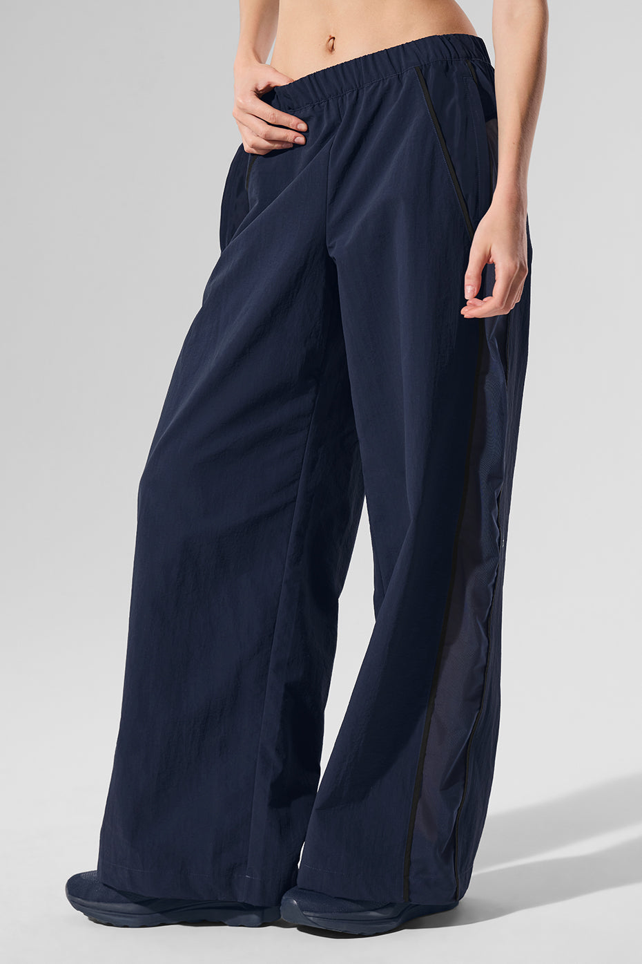 Front view of navy/black high-waisted wide leg track pants on a model.