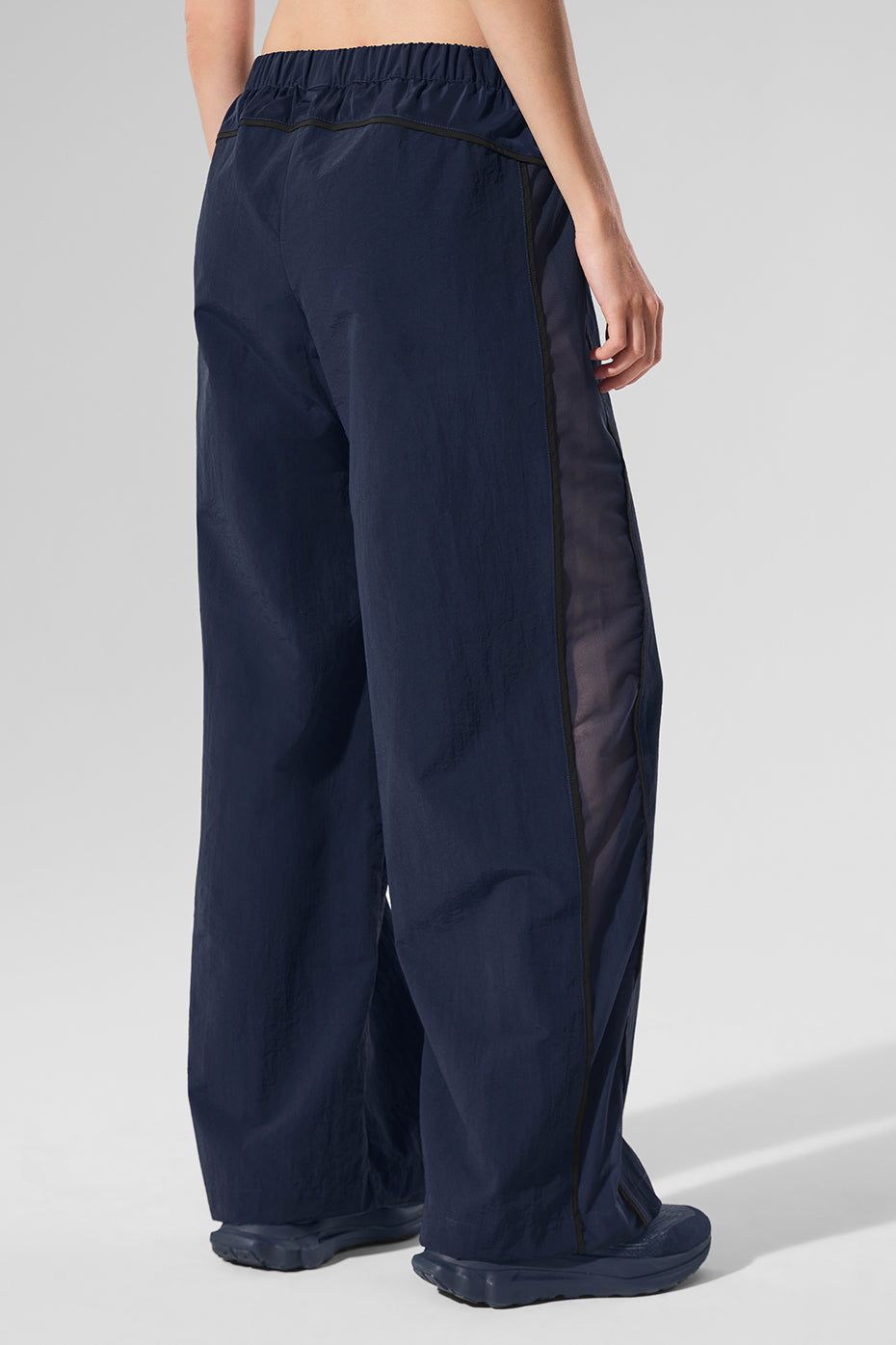 Back view highlighting the tonal piping detail of the track pants.