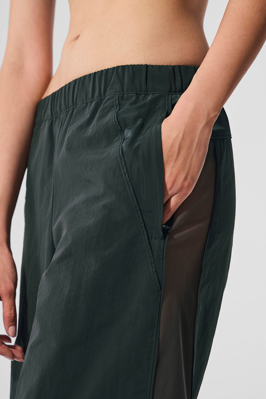 Front view of Charcoal Green high-waist wide leg track pants on a model in a yoga studio.