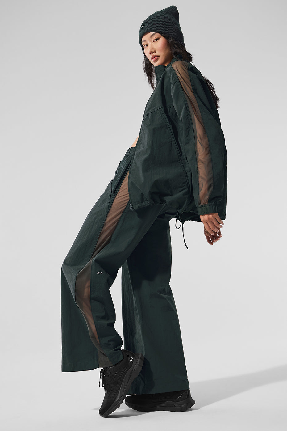 Side view showcasing the mesh paneling of the wide leg track pants.