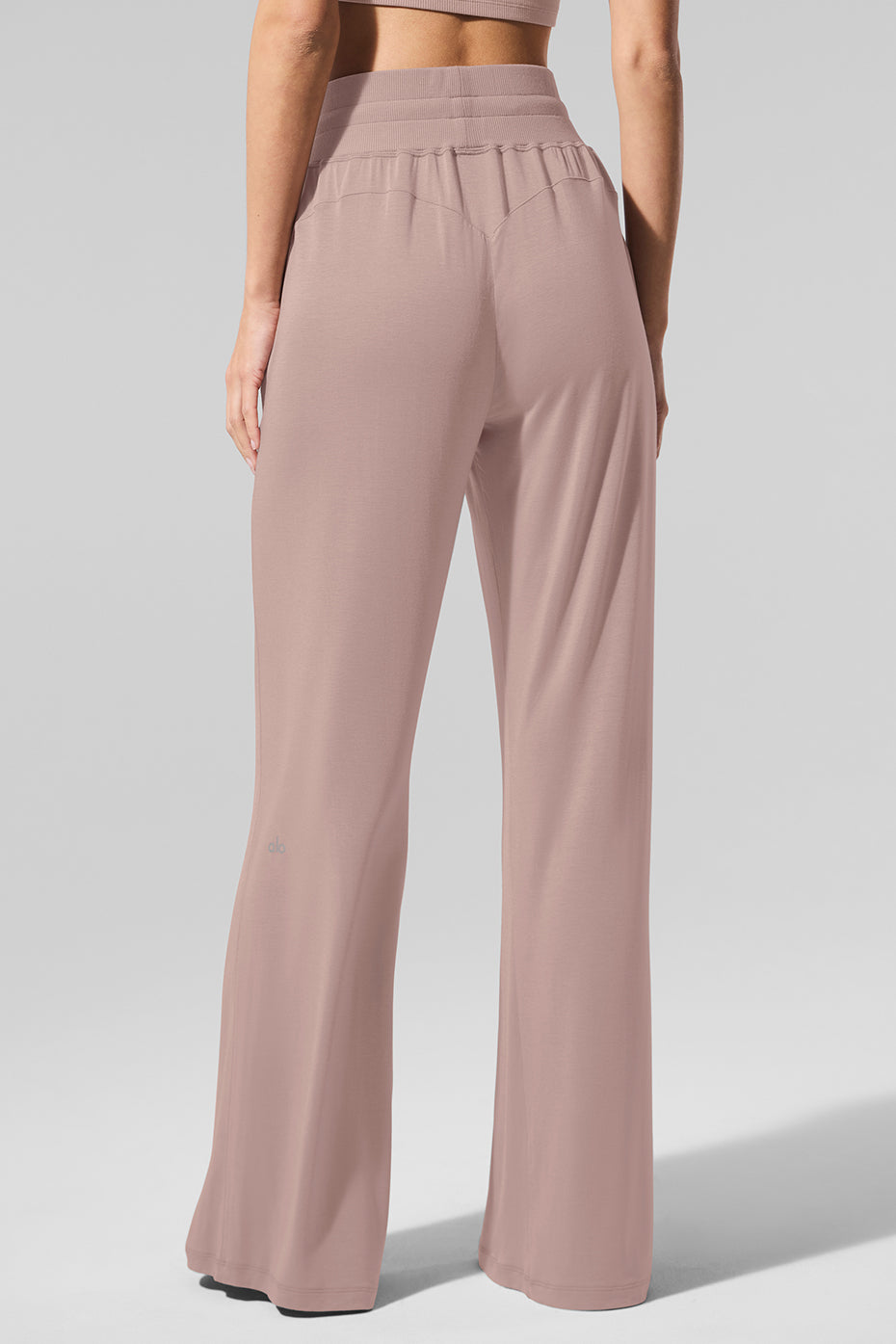 Model wearing taupe flare yoga pants, styled with a casual top.