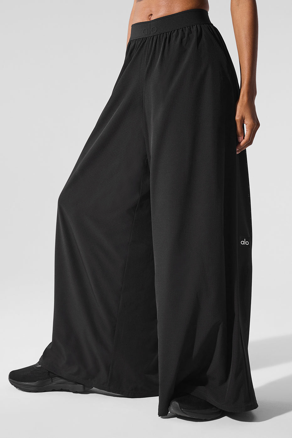 Model walking outdoors in pants mesh style near a coastal walkway