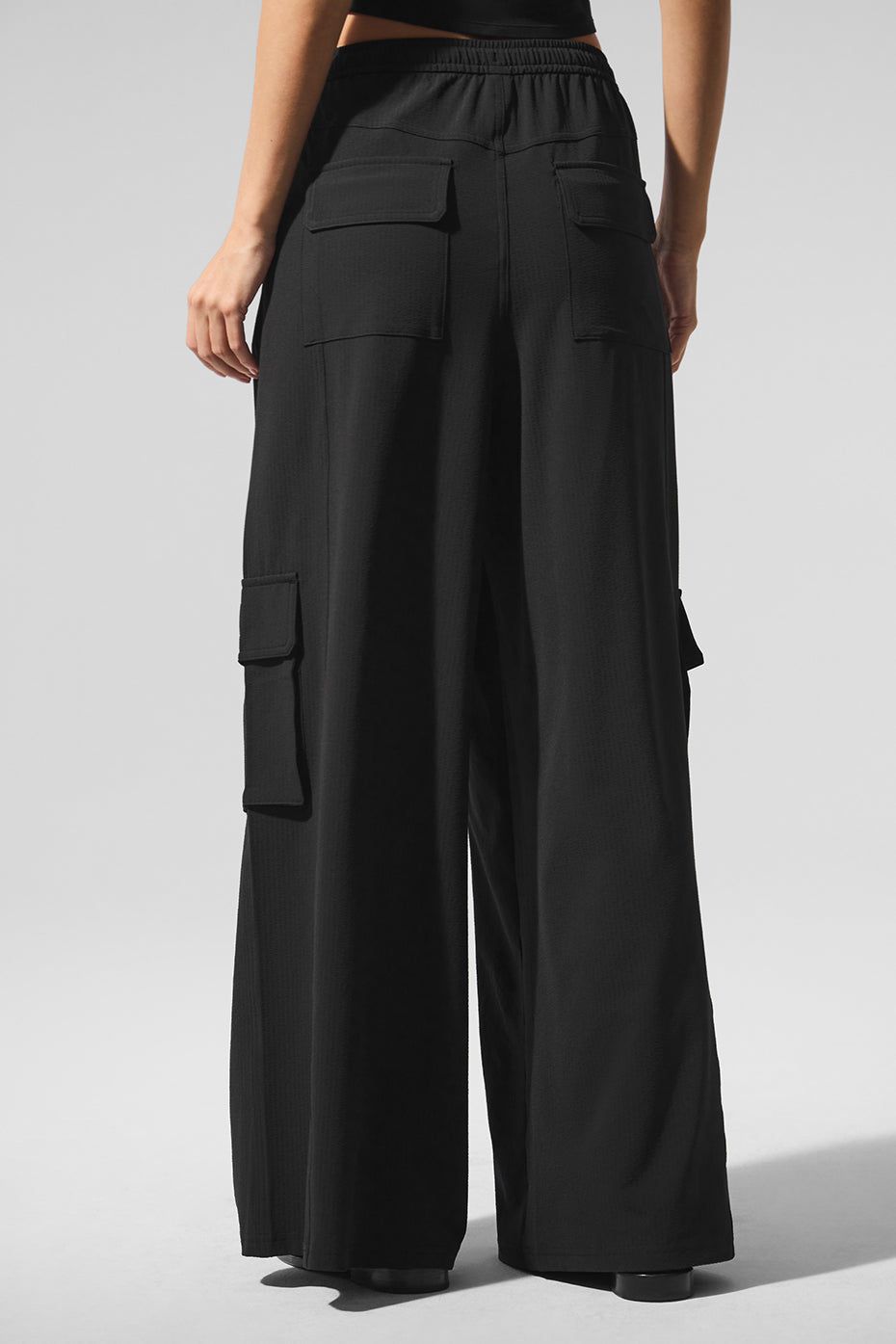 Front view of black cargo pants showcasing wide leg design.