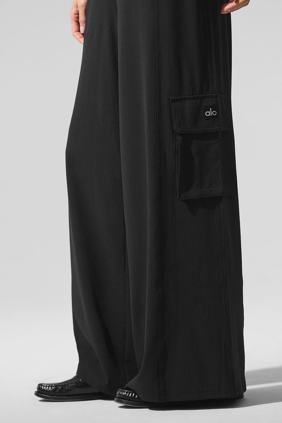 Model wearing black cargo pants in a summer outdoor setting.