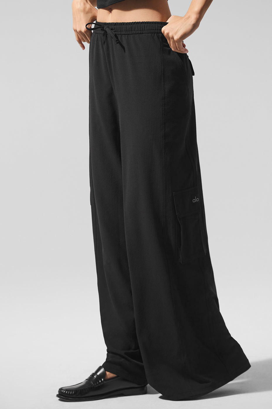 Front view of black cargo pants showcasing wide leg design.