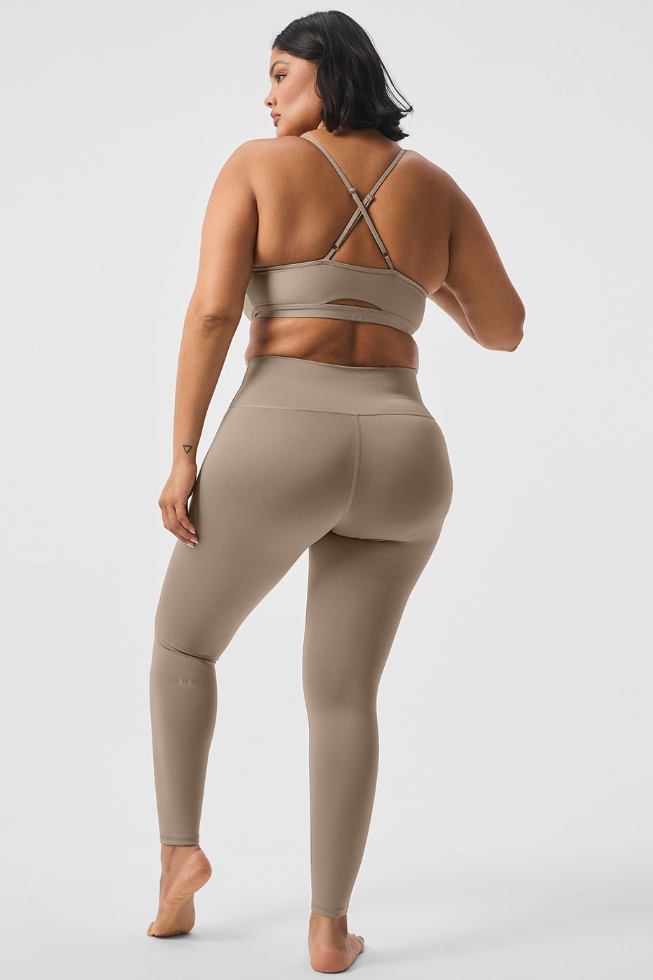 Model wearing gravel-colored compression leggings in a yoga pose