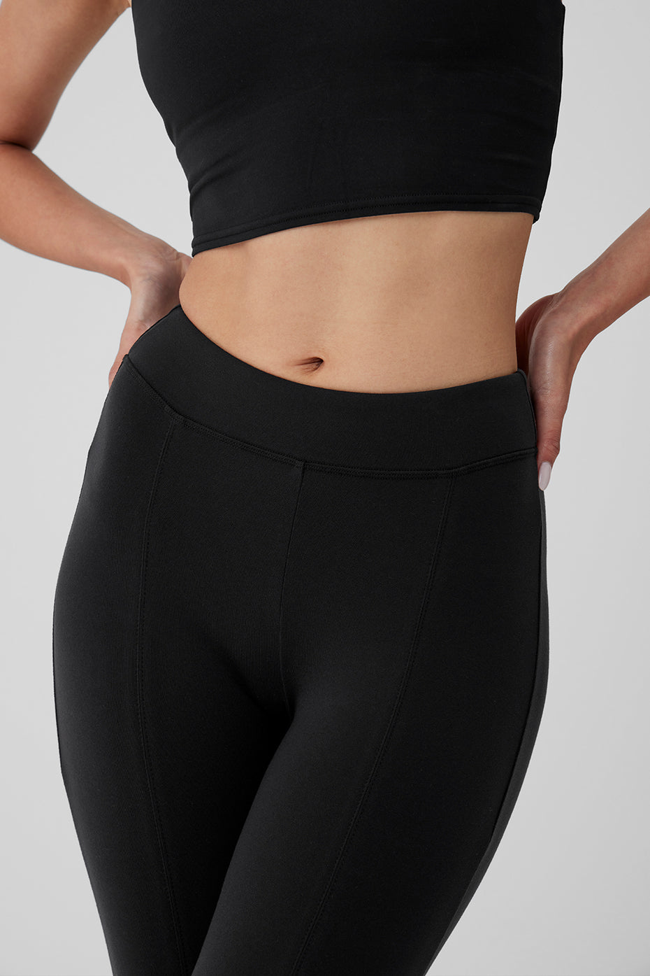 Side view of black leggings highlighting the flared leg and flattering fit.