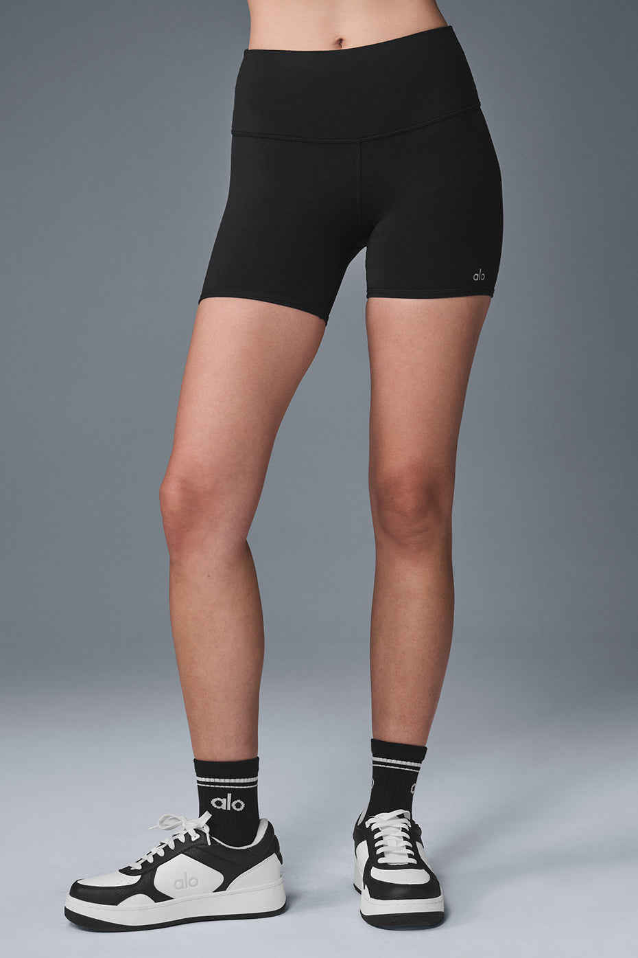 Back angle of women bike shorts styled with a cropped tank, showcasing sporty 5-inch inseam