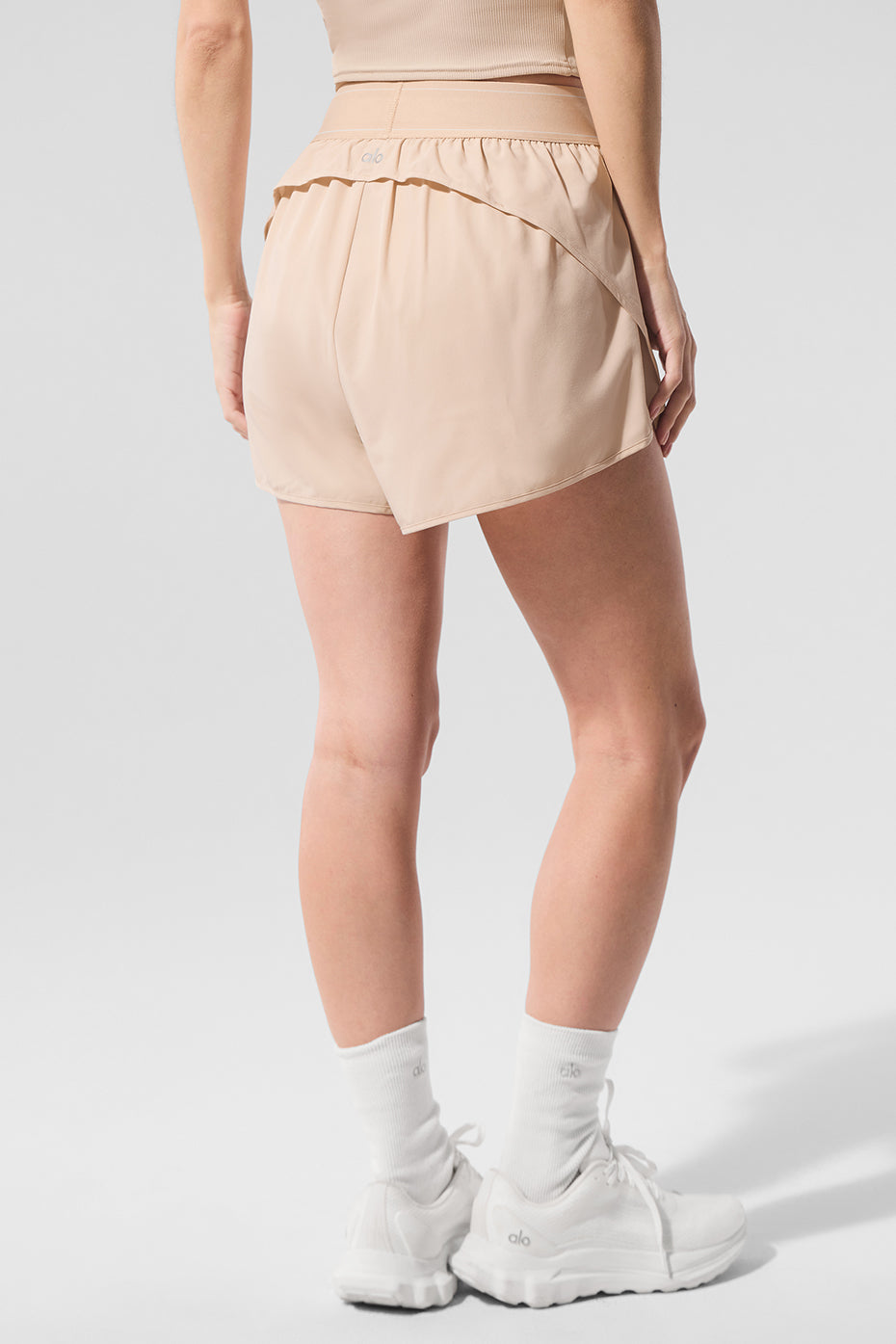 Front view of macadamia high-cut tennis shorts for women, showcasing the relaxed fit.