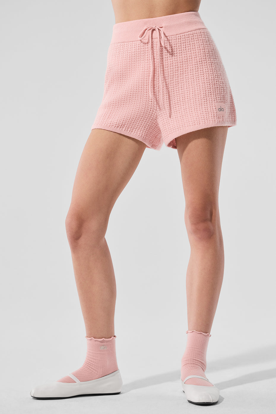 Front view of plush cashmere high-waist swim shorts in pink quartz on model