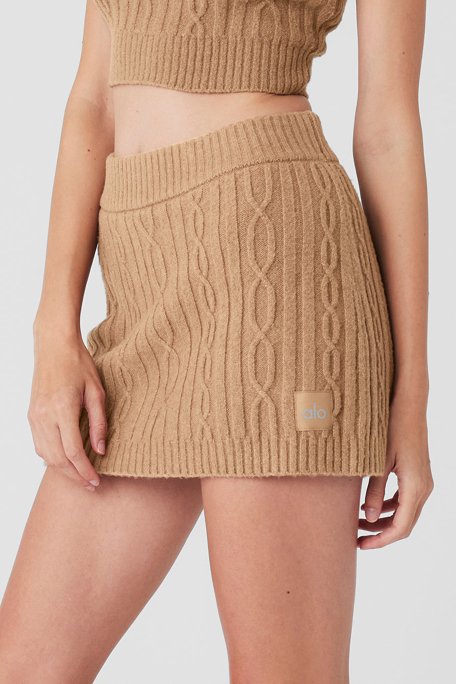 Close-up of the fabric texture of the cable knit mini skirt, showcasing its softness.