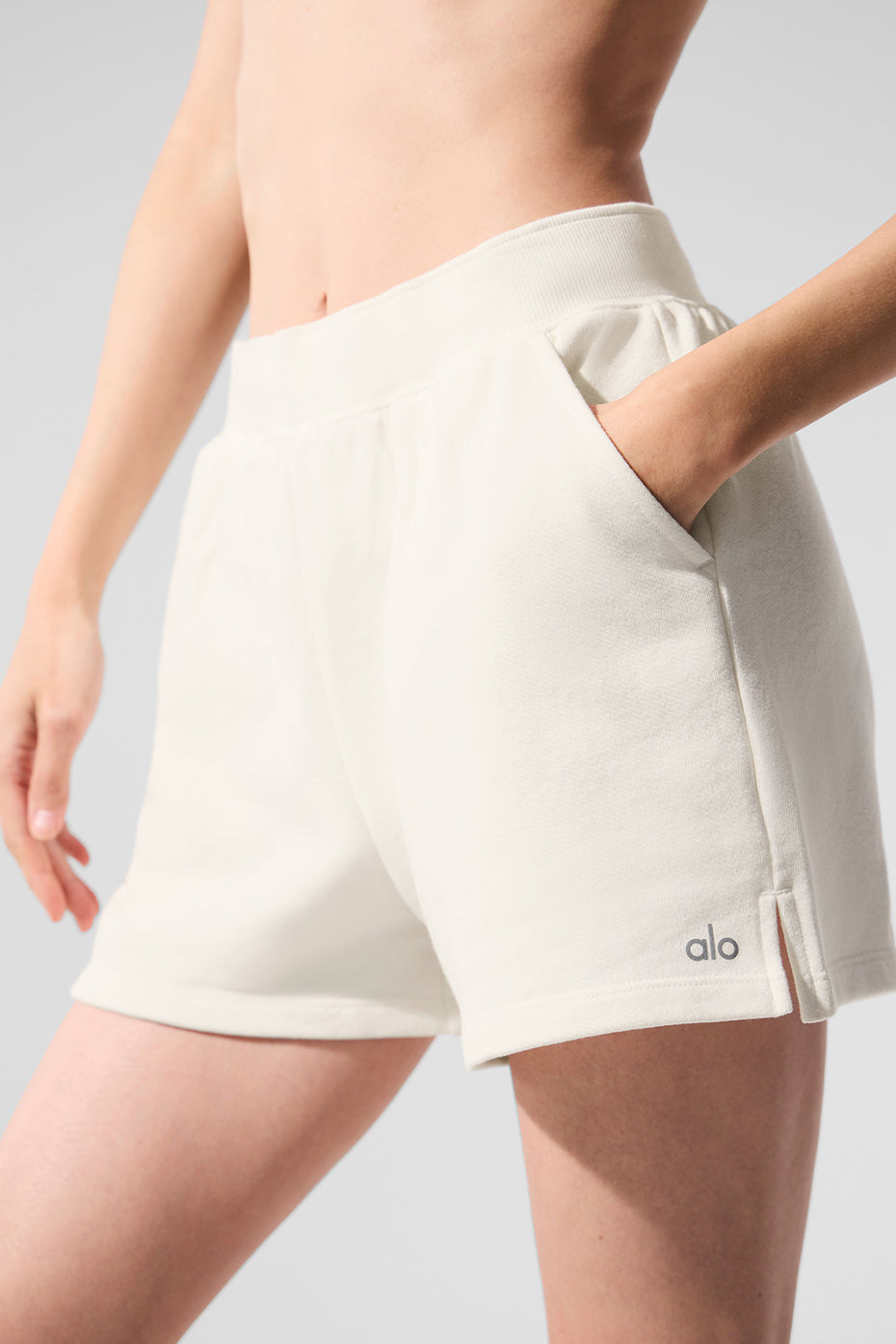 Front view of chic high rise sweat shorts in ivory, showcasing side pockets.