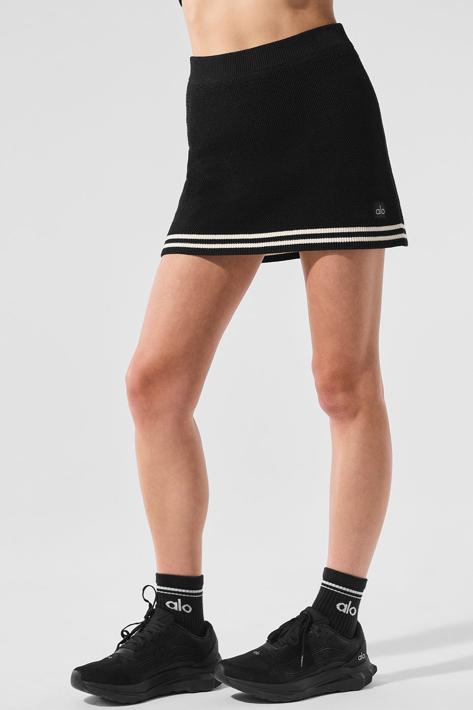 Front view of the black and ivory pleated tennis skirt, showcasing its stylish design.