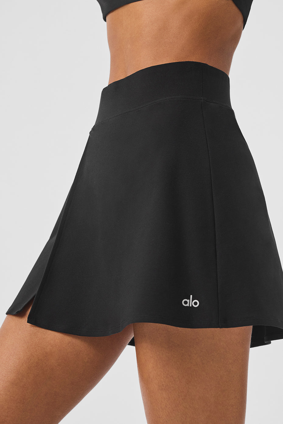 Close-up of the fitted waist and side slit of the Alo Yoga Backspin Skirt.