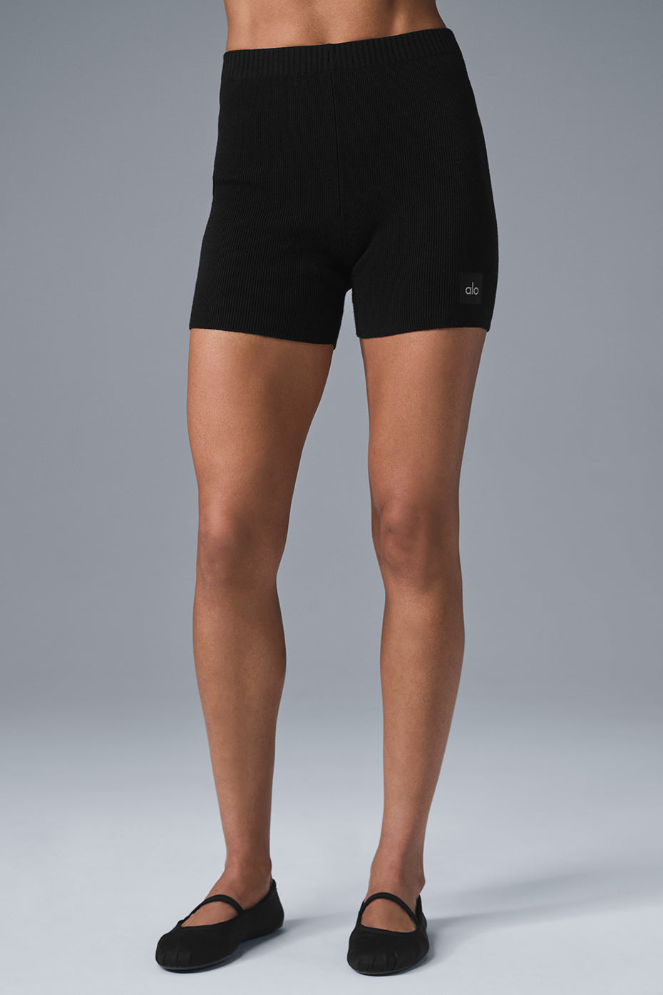 Front view of high waisted denim shorts styled with sneakers and scrunched socks