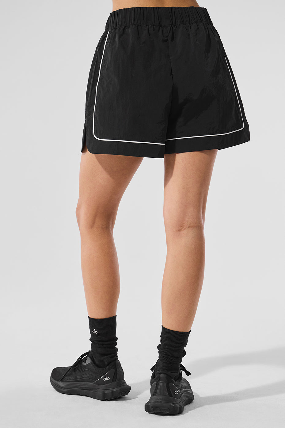 Side view of black and white womens track shorts with contrast piping