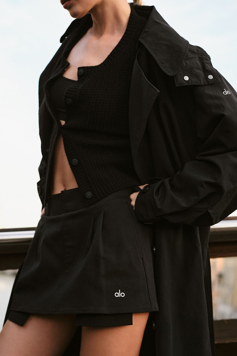 Front view of the black pleated mini skirt styled with a cropped tee.