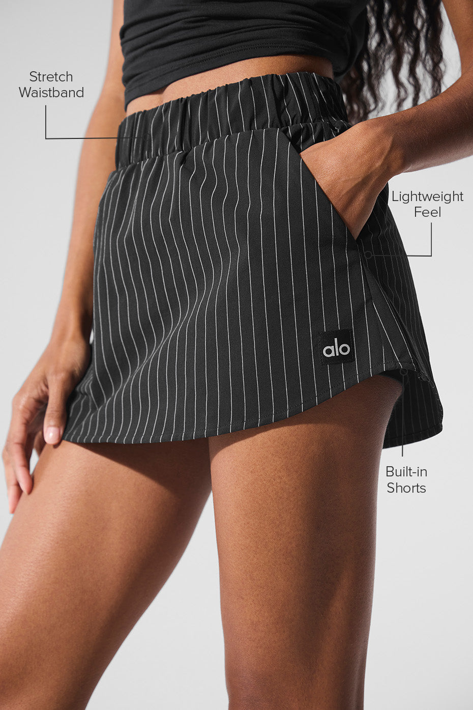 Side angle of black pinstripe mini skirt showcasing built-in shorts.