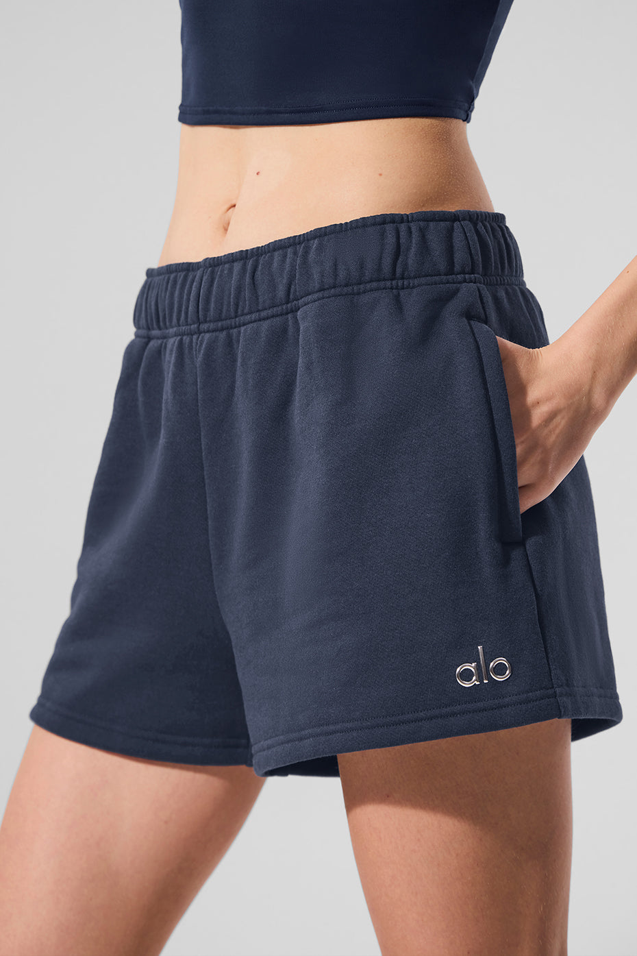 Front view of navy loungewear shorts on a model in a cozy living room