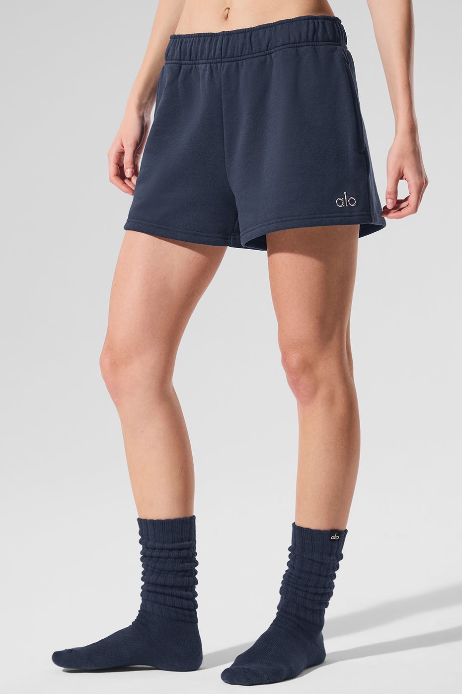 Front view of navy loungewear shorts on a model in a cozy living room