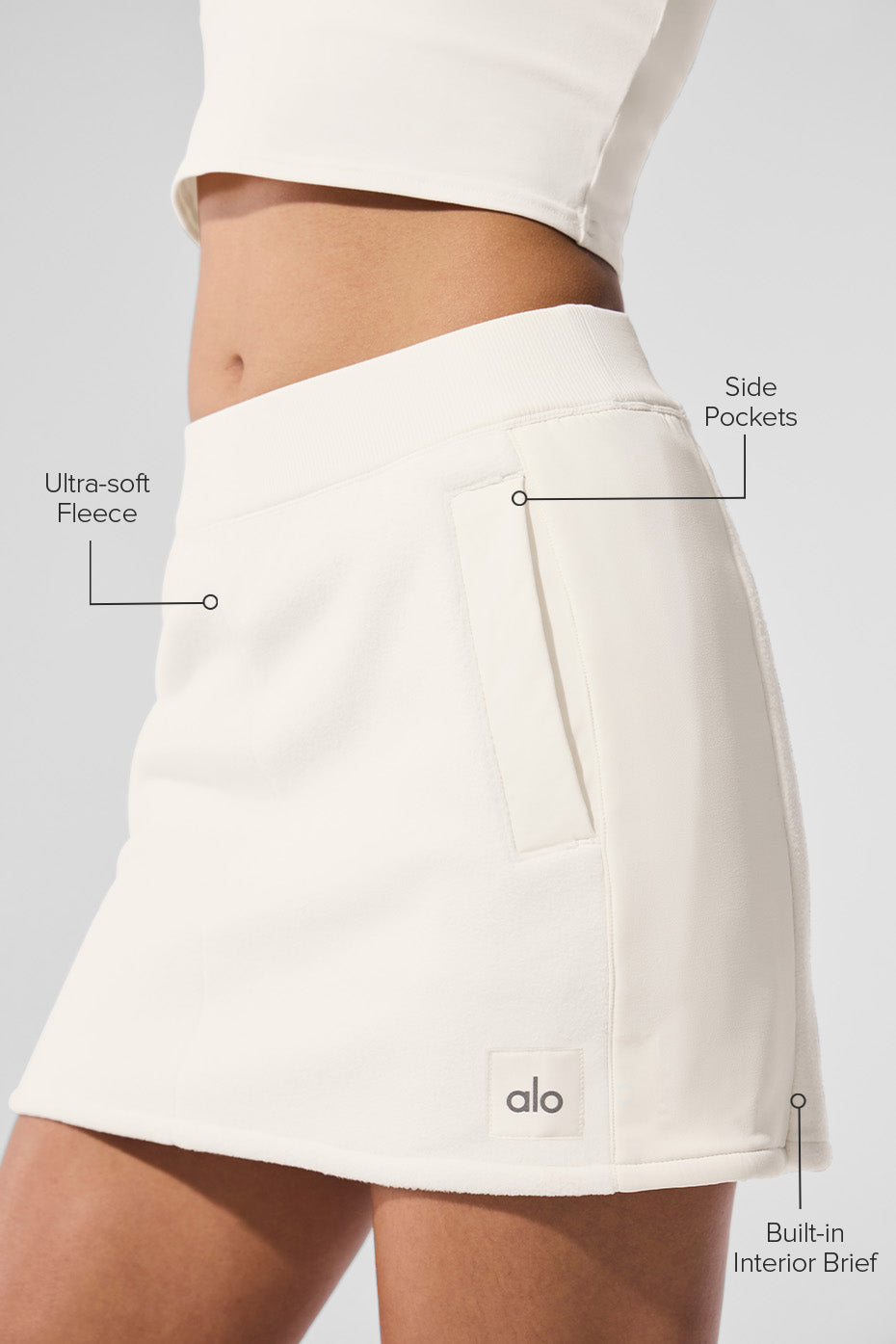 Side view of the ivory fleece skirt, highlighting the ribbed waistband and pockets.