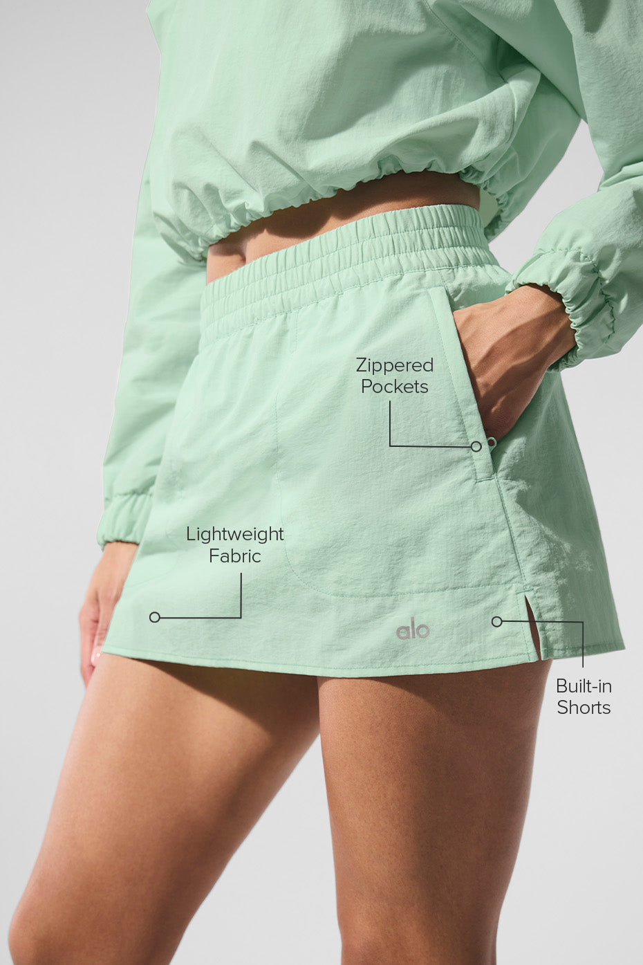 Side view showcasing the hemline slits of the Alumni tennis skirt.