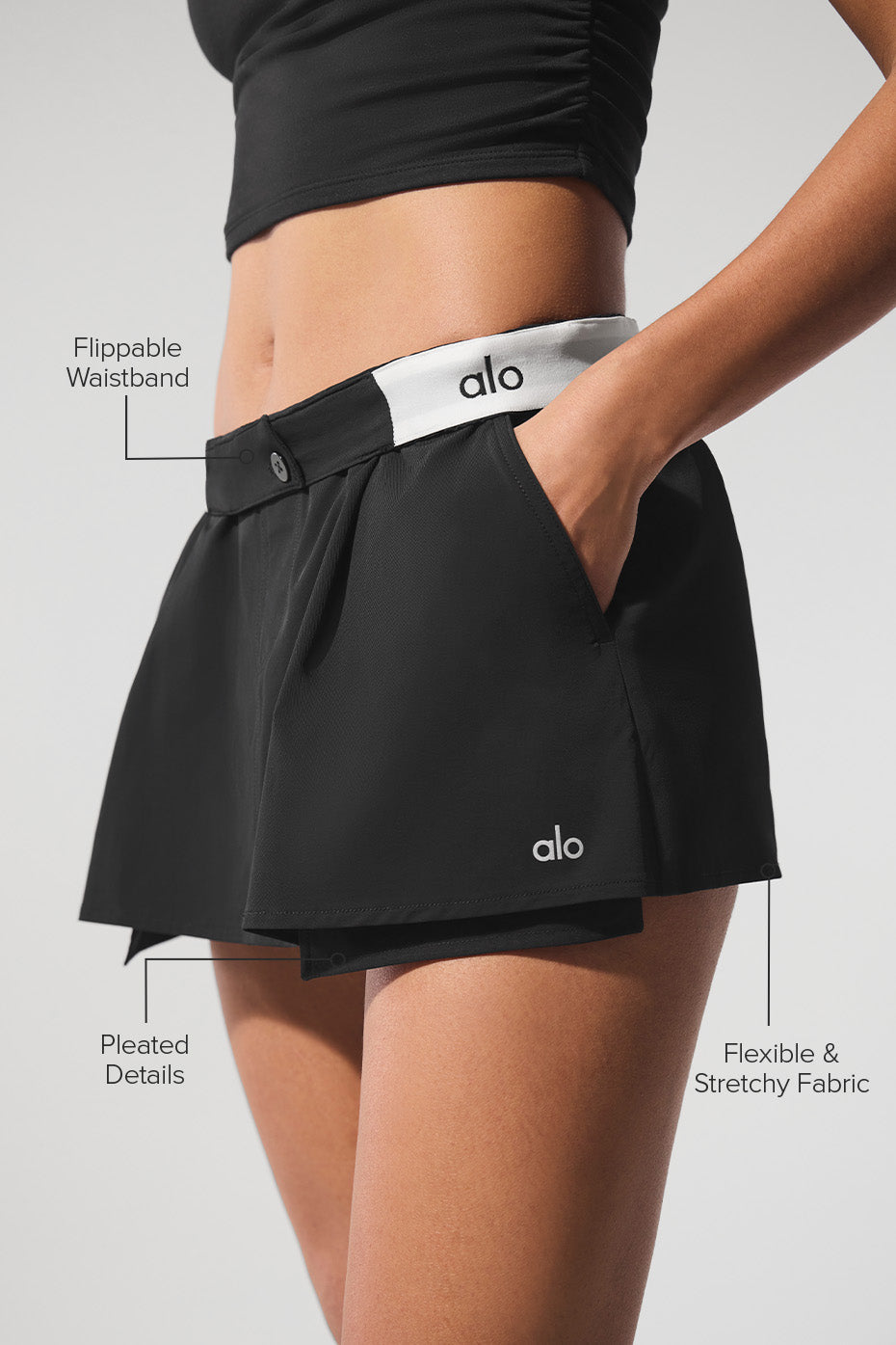 Front angle of flip it skort with flipped waistband revealing logo, styled with crop top