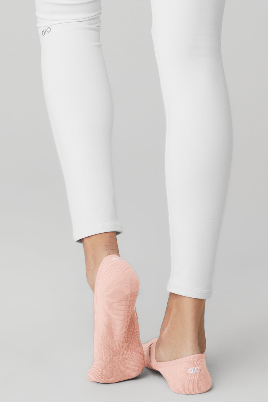 Woman wearing grip socks during a Pure Barre class, feet in first position