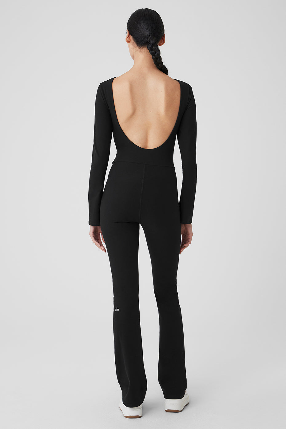 Side view highlighting the boat neck and bell sleeves of the black onesie.