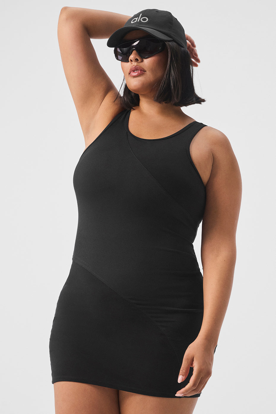 Side angle of black long sleeve mini dress showing ribbed torso and scoop back