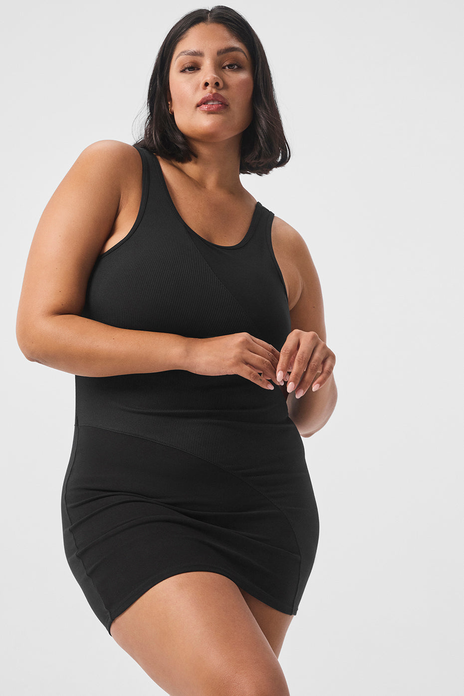 Side angle of black long sleeve mini dress showing ribbed torso and scoop back