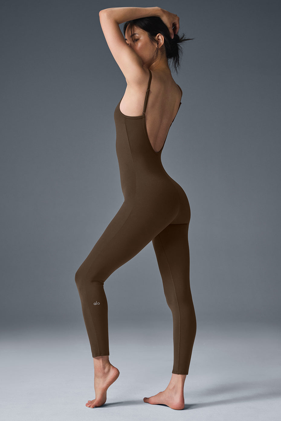 Side angle of the black jumpsuit, demonstrating the sculpting Airbrush fabric.