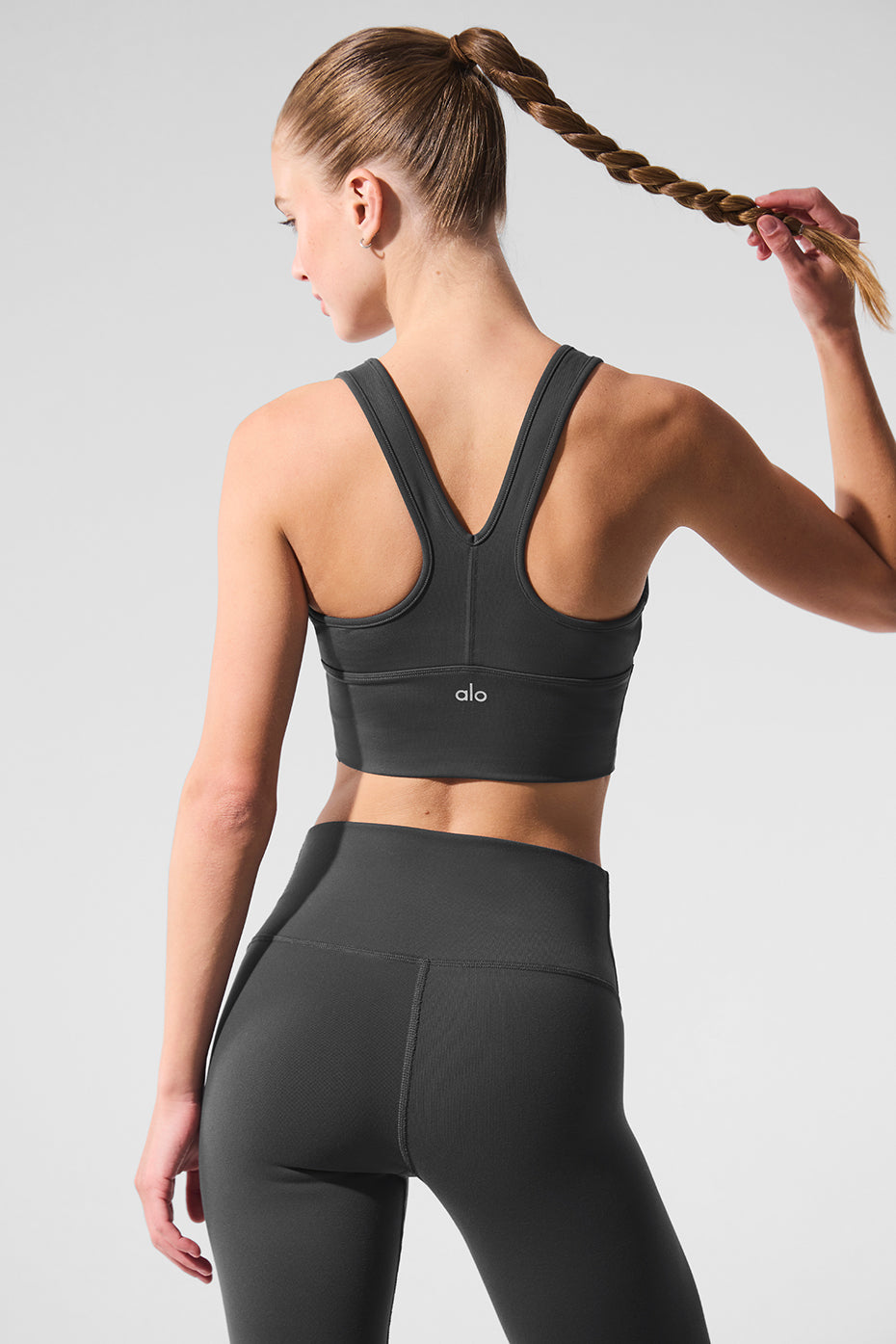 Model wearing crop top bra with yoga pants in outdoor setting