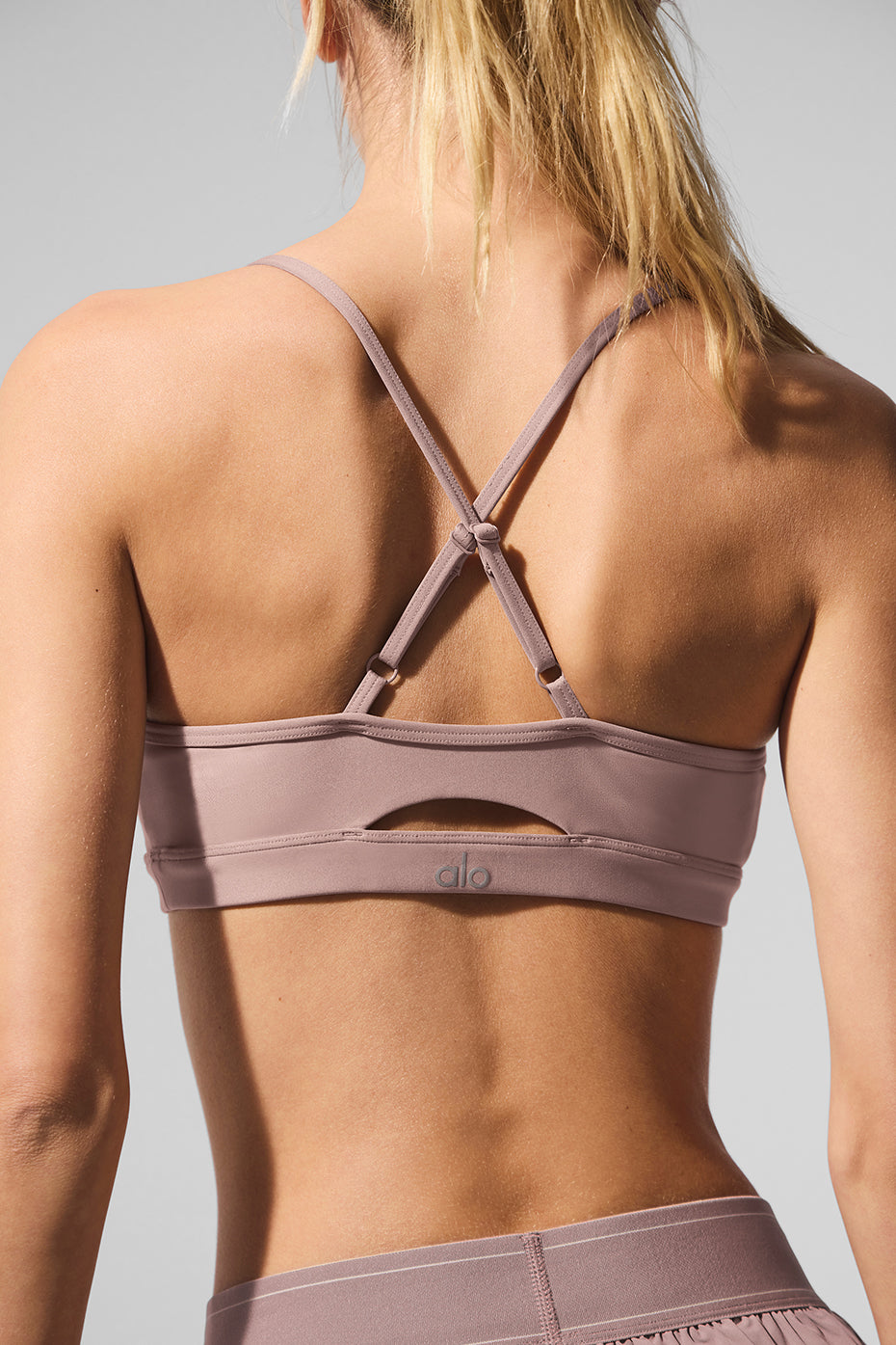 Side angle of the taupe yoga sports bra, highlighting keyhole detail.