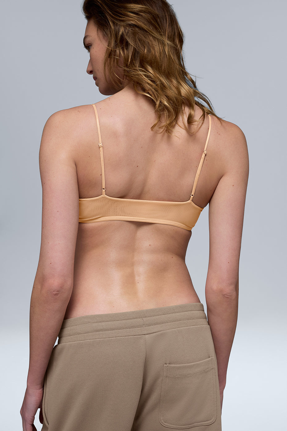 Side angle of bralette worn under a light blouse during casual city stroll