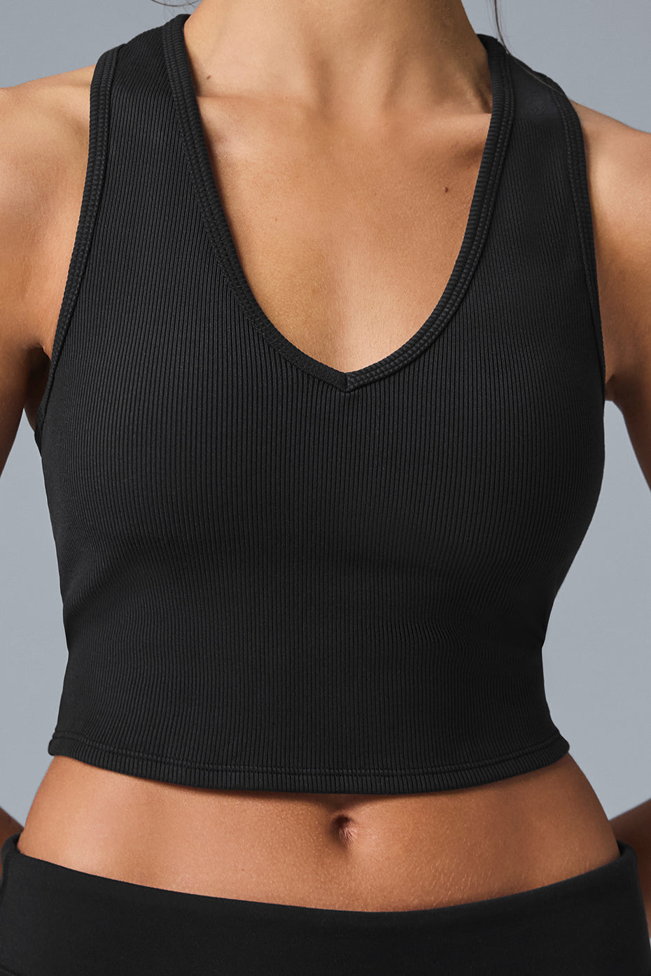 Close-up of the ribbed knit fabric and shoulder straps of the cropped tank top