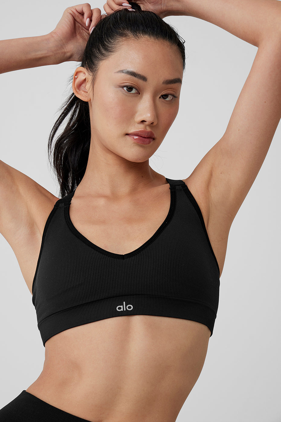 Woman wearing black seamless sports bra during yoga pose, highlighting flexibility.