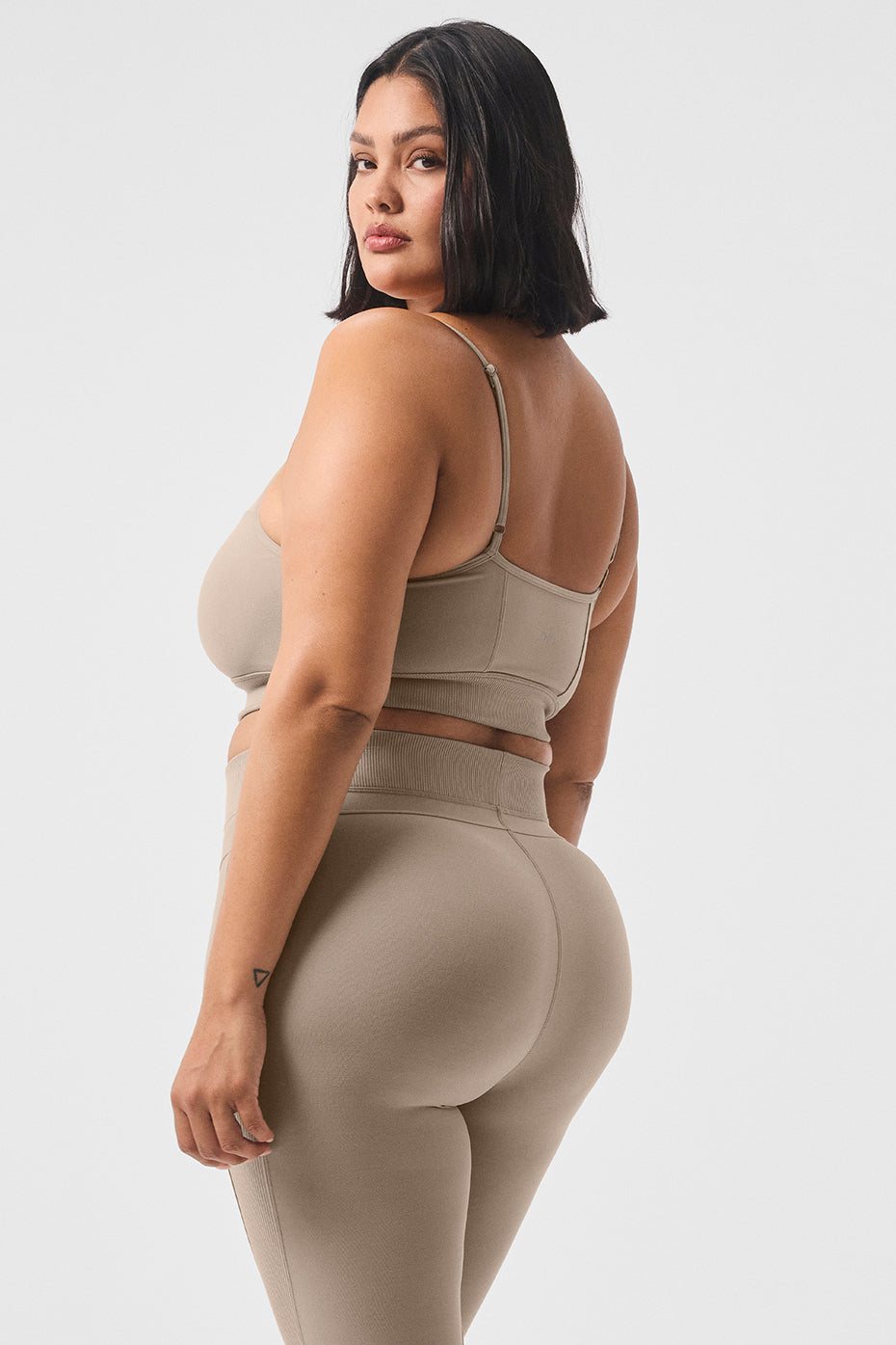 Side angle of the sports bra showing contour seaming and wide ribbed underbust band