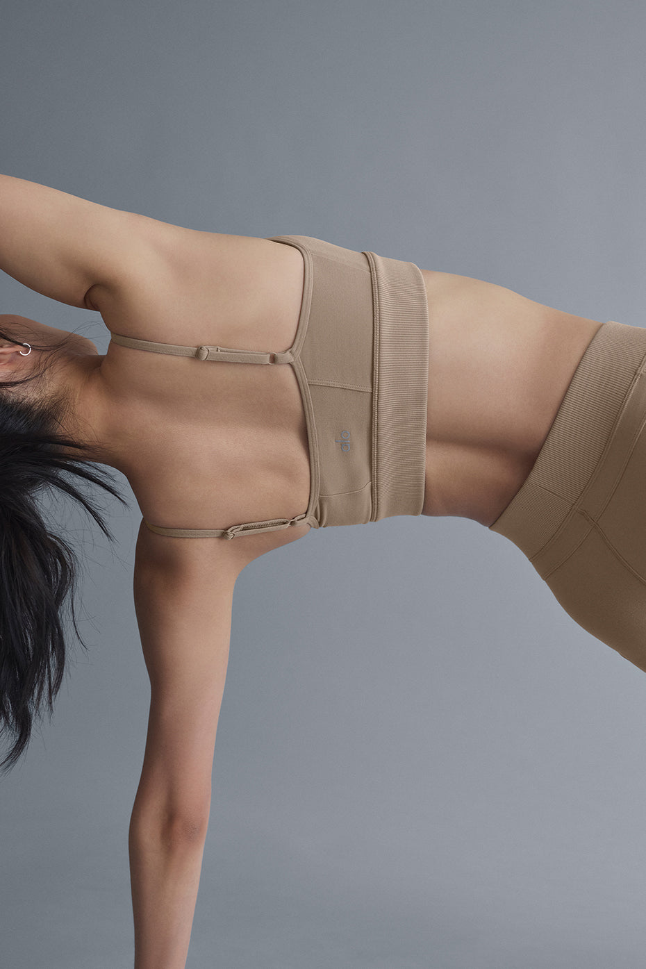 Side angle of the sports bra showing contour seaming and wide ribbed underbust band
