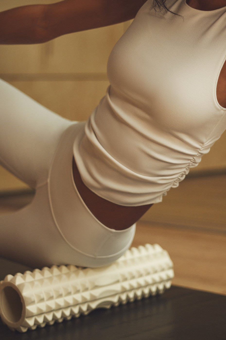 Front view of the ivory ribbed crop top styled with leggings.