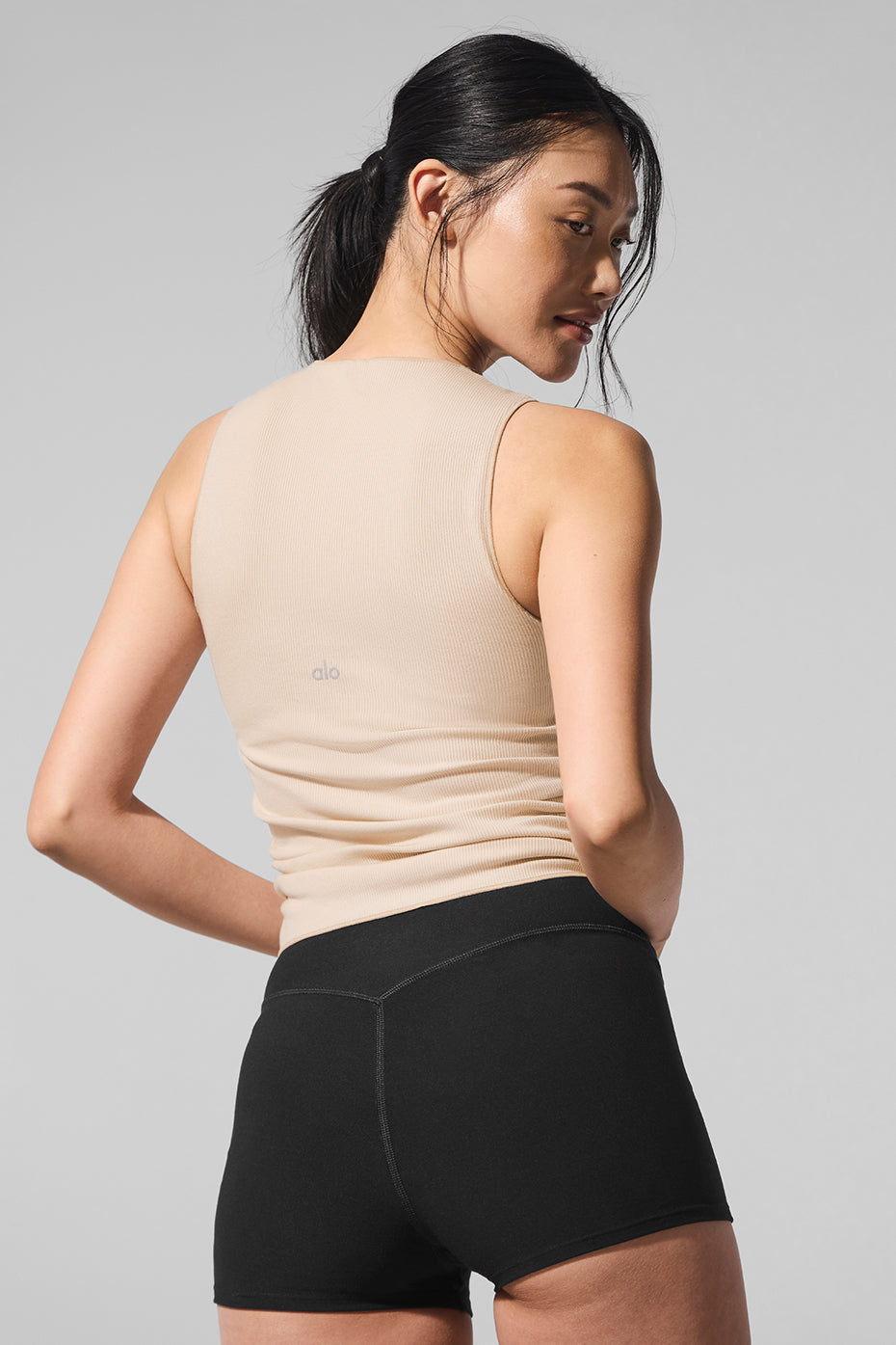 Back view showing the double-layered design of the white ribbed tank top.