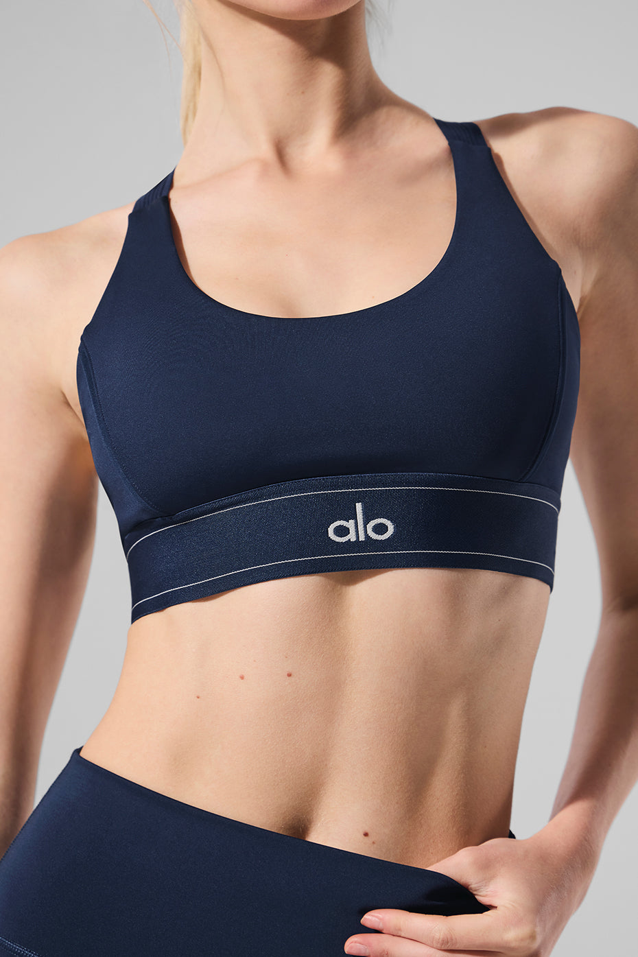 Woman jogging in navy Airlift Intrigue Bra, highlighting medium-impact performance