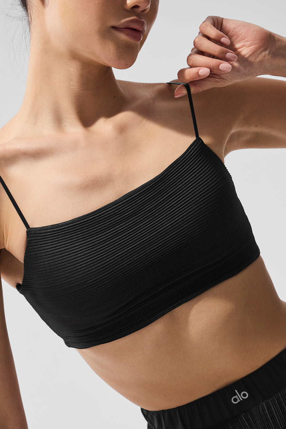 Black pleated sports bra displayed on a mannequin, ideal for tennis players.