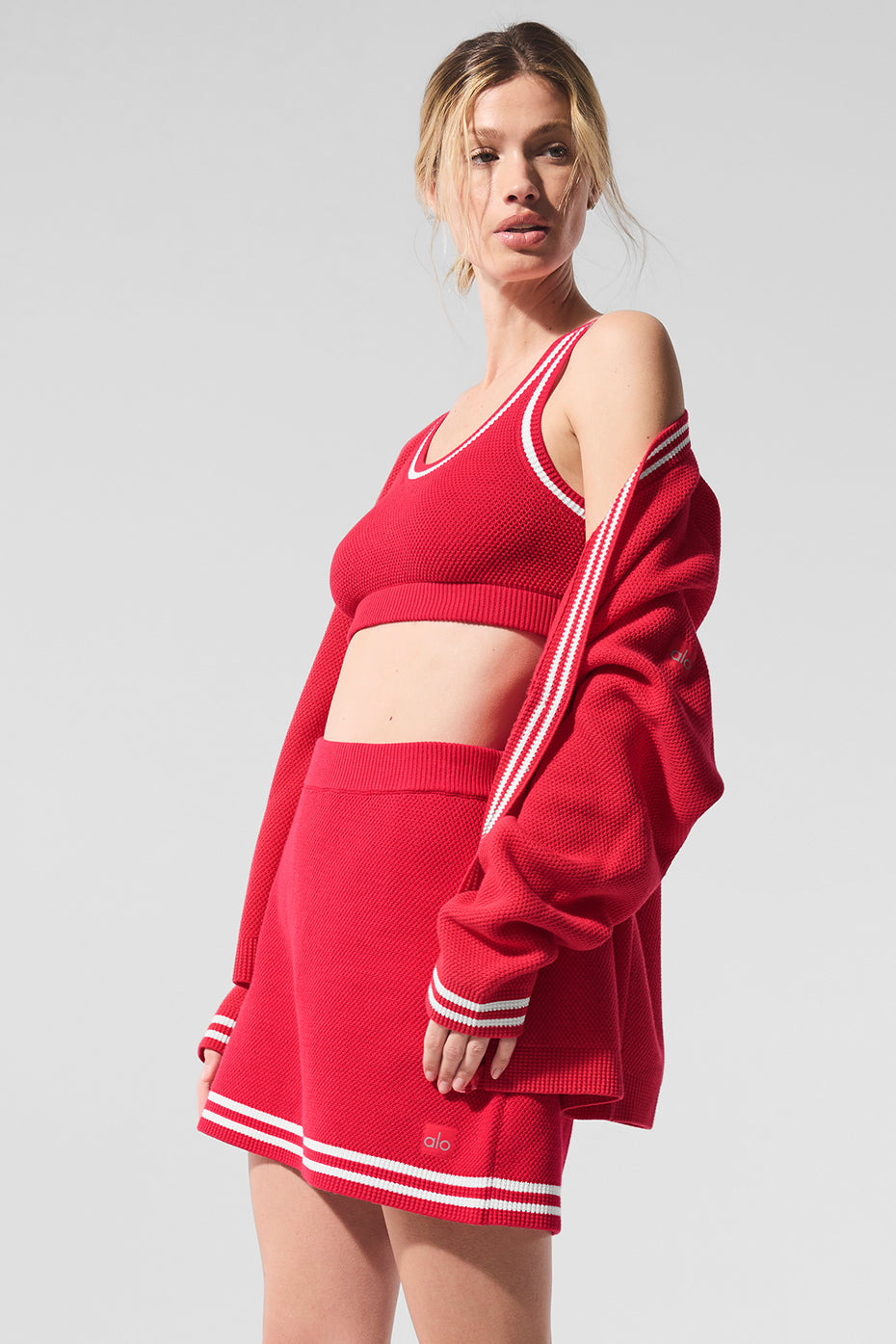 Model wearing the vibrant red and white tennis outfit women love on the court